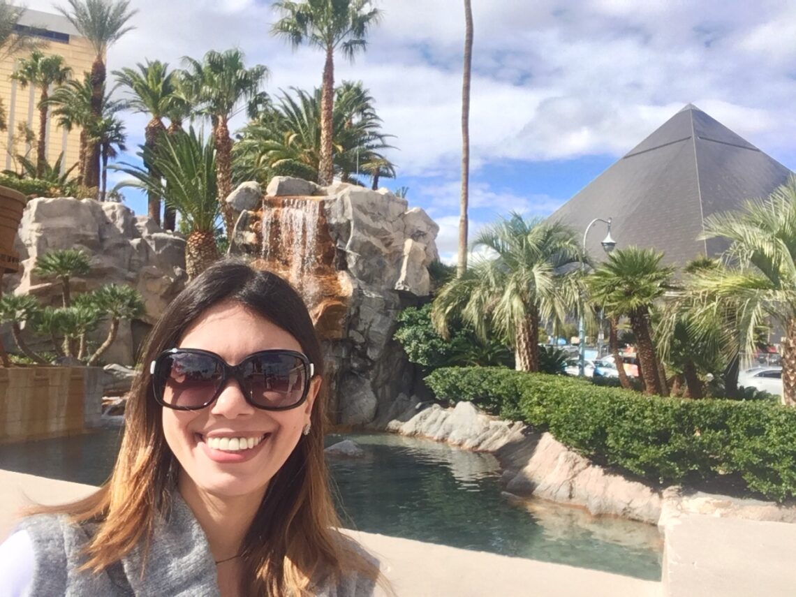 mulher posando para foto em frente a uma pirâmide com palmeiras em Las Vegas