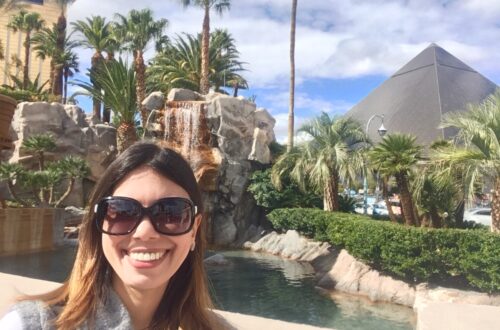 mulher posando para foto em frente a uma pirâmide com palmeiras em Las Vegas