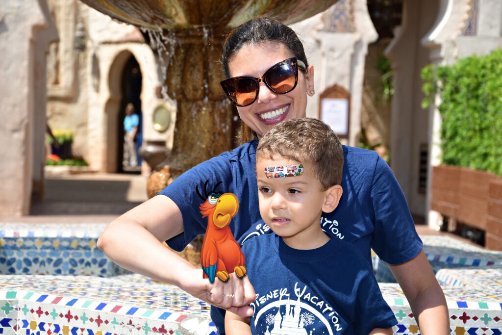 mãe e filho no Epcot Center segurando um papagaio digitalmente inserido na imagem