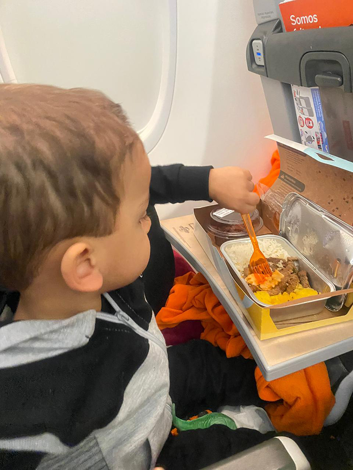 criança comendo refeição no avião da Gol