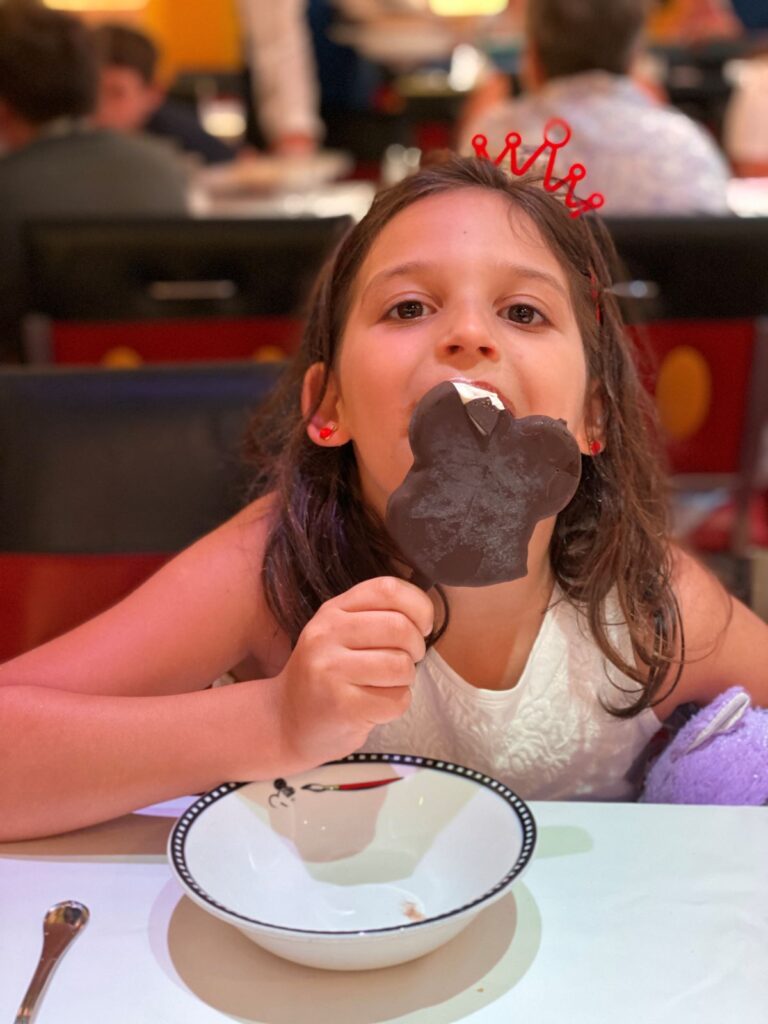 criança de 5 anos no cruziero da Disney comendo um sorvete no formato no Mickey