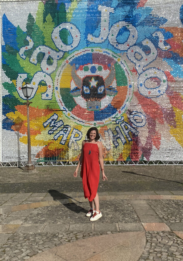 mulher posando para foto com vestido vermelho em frente a um letreiro de São João do Maranhão