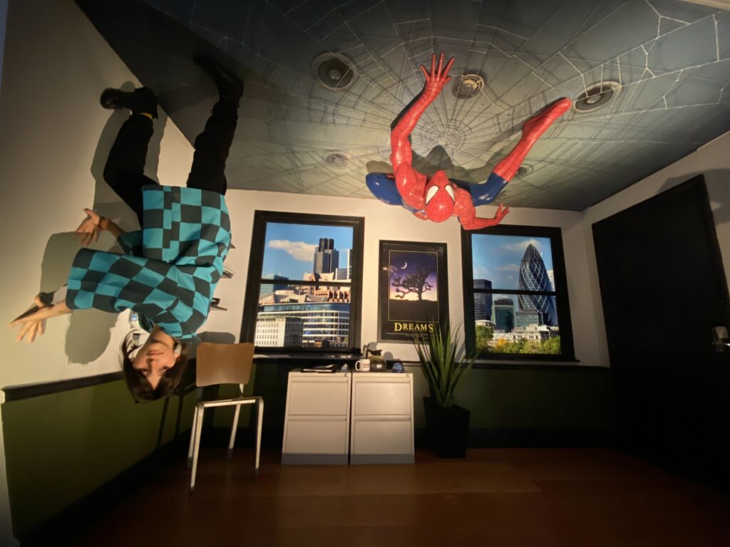 cenario interativo para foto, apartamento do homem aranha, ele pendurado no teto e uma criança escalando a parede