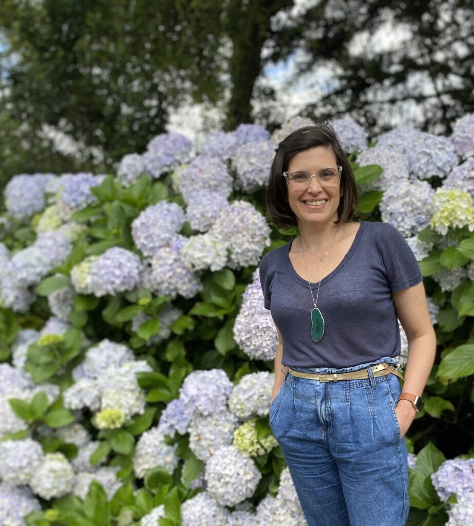 mulher posando em frente a jardim de hortensias azuis