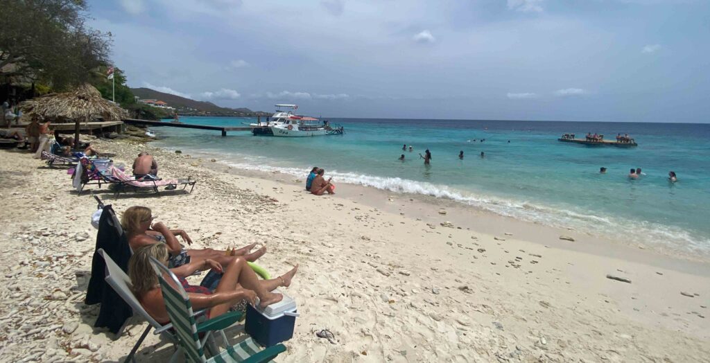 praias de curaçao com areia branca e mar azul, pessoas tomando banho de mar