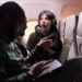 Multiethnic group of people flying abroad in economy class, using laptop, smartphone and headphones during sunset flight. Passengers travelling with international commercial airline.