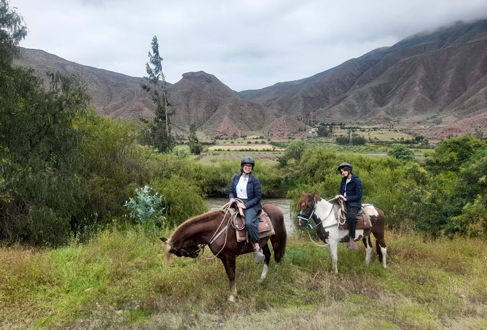 Dois cavalos com turistas fazendo passeio no vale sagrado do Peru