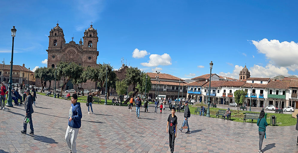 plaza de armas de cusco em um dia de sol com pessoas caminhando