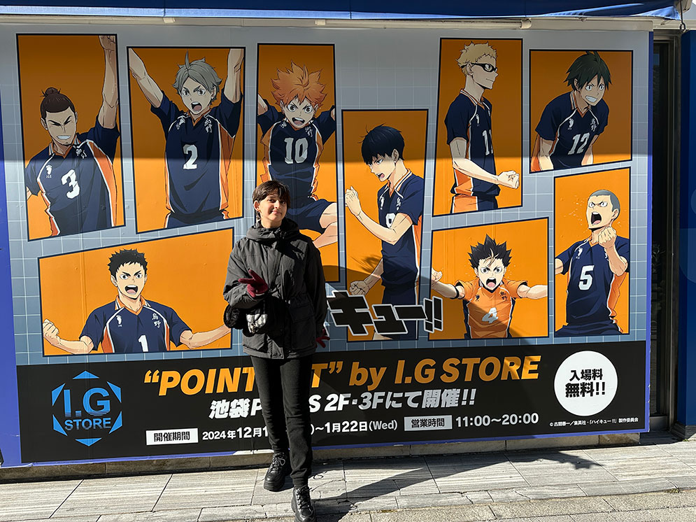menina tirando foto em Toquio na frente de uma painel de mangá