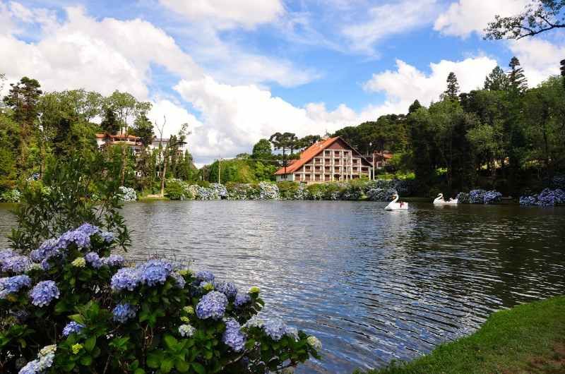 lago negro de gramado com flores e pedalinhos