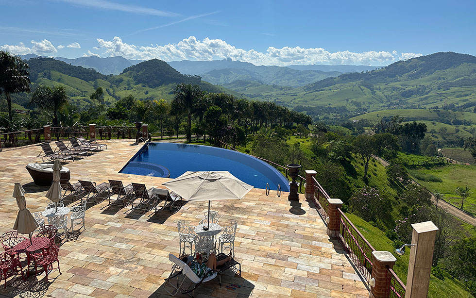 psicina de borda infinita com deck e mesinhas da pousada Aldeia Manacás.