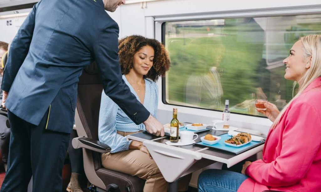 Duas mulheres sendo servidas por um comissário no trem da Eurostar