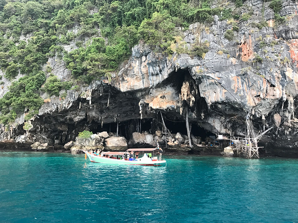 as águas azuis que circunadam a Viking Cave na Tailândia